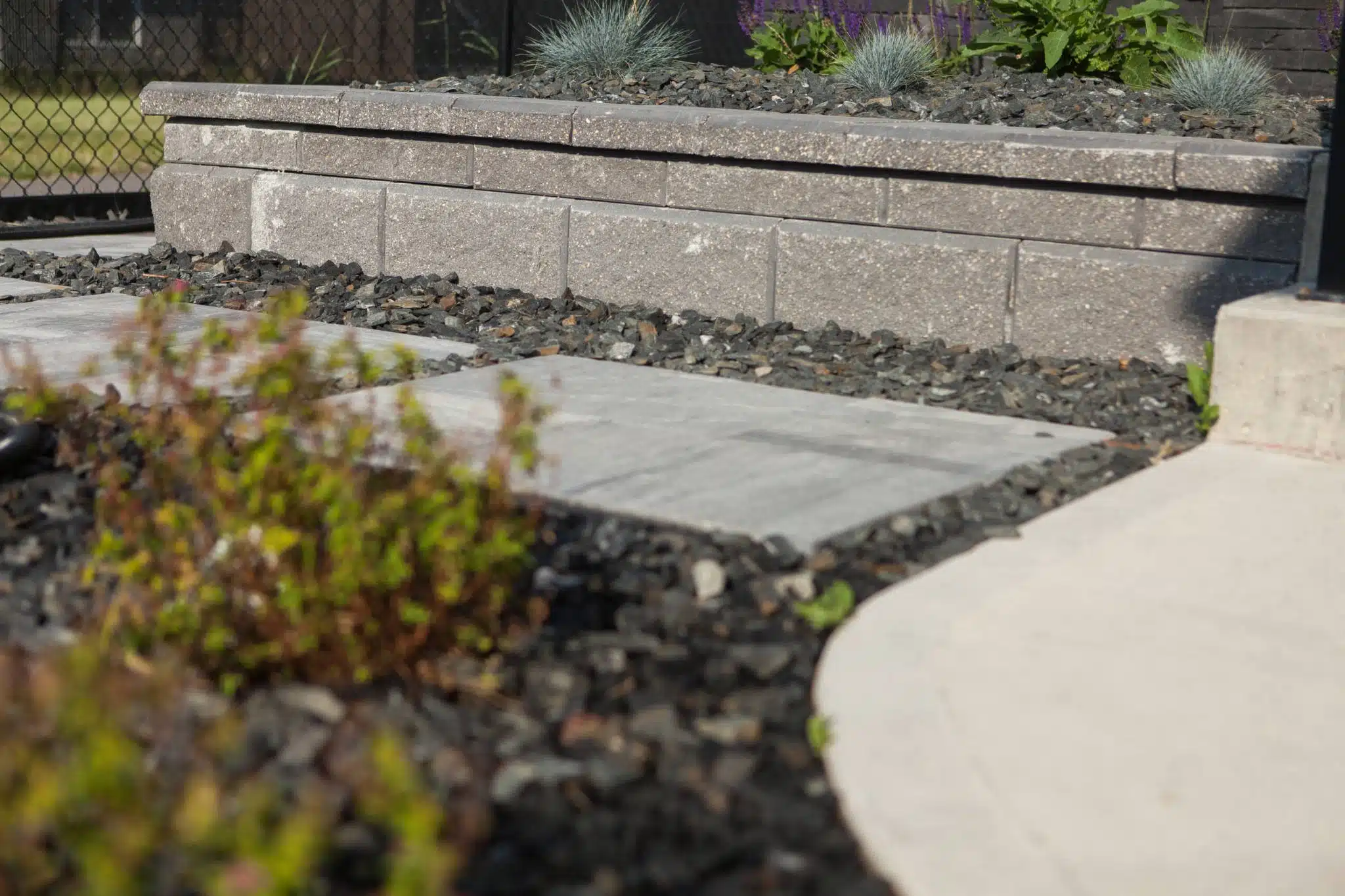 Detail of brick retainer wall and stone block walkway.