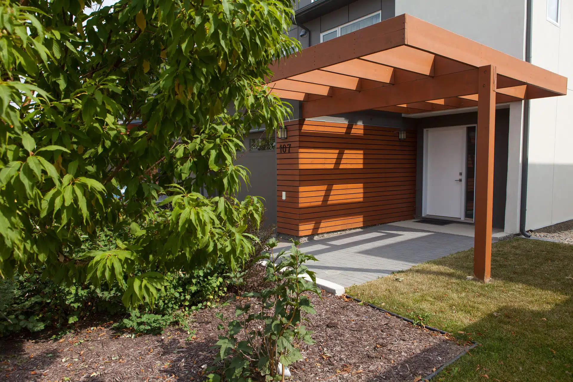 Pergolas and planting bed at apartment building entrance.