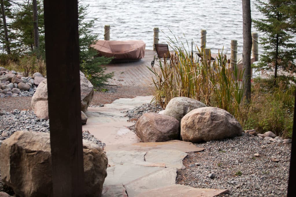 Stone walkway and rock features leading to dock at lake front property.