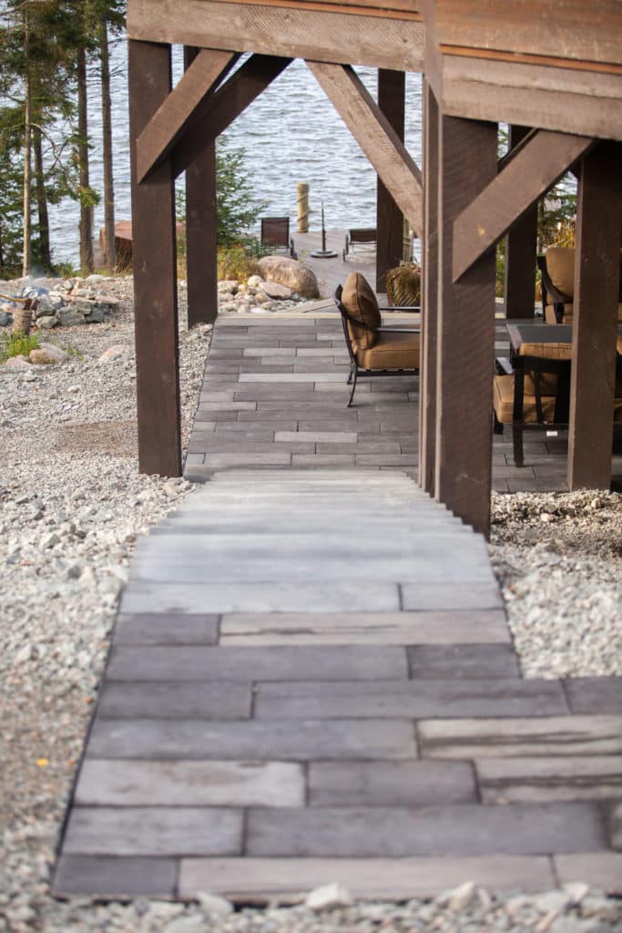 Brick stairs leading down to a brick patio, with gravel landscaping on either side, at a cabin property.