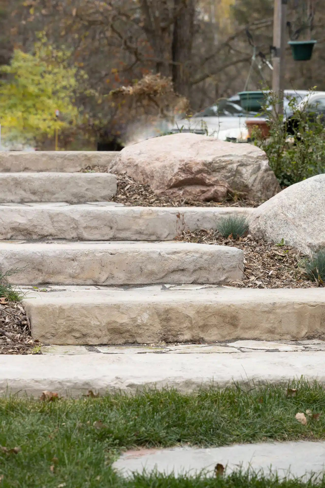 Rustic stone steps lead through a natural landscape with large boulders
