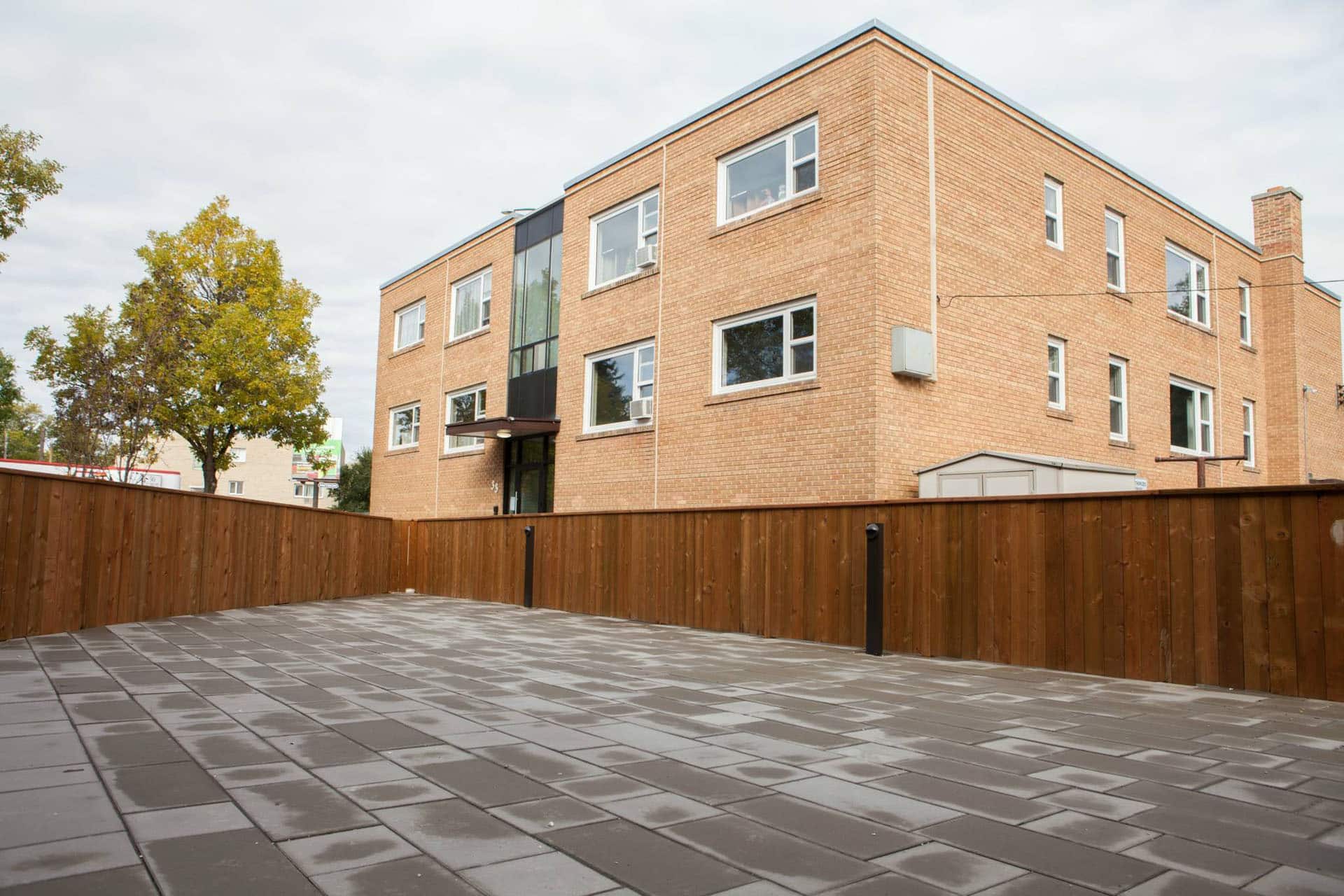 Large commercial wooden fence and brick patio for apartment building.