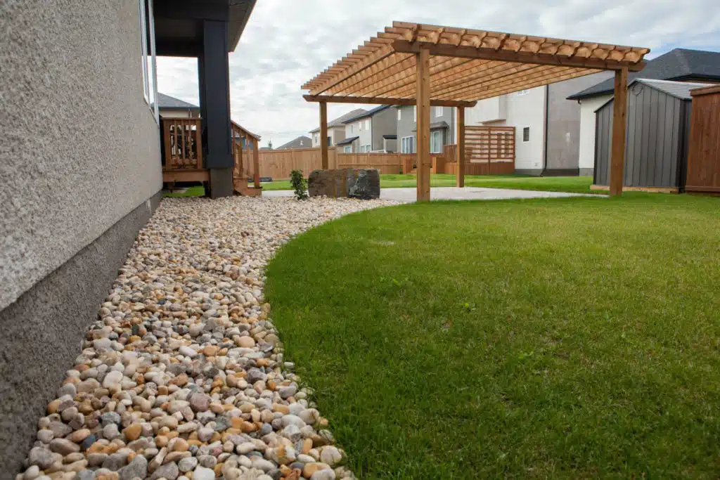 Backyard with wooden pergola, stone accents, and a small patch of grass