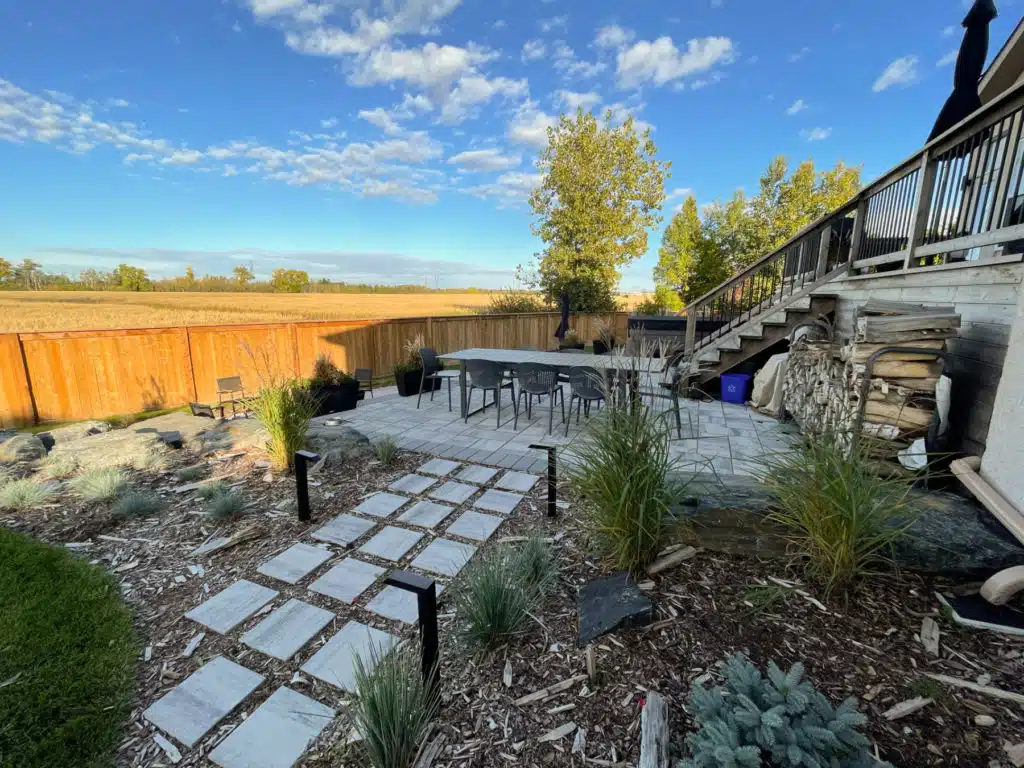 Modern stone slab patio and walkway, with fire pit, lined with outdoor lights