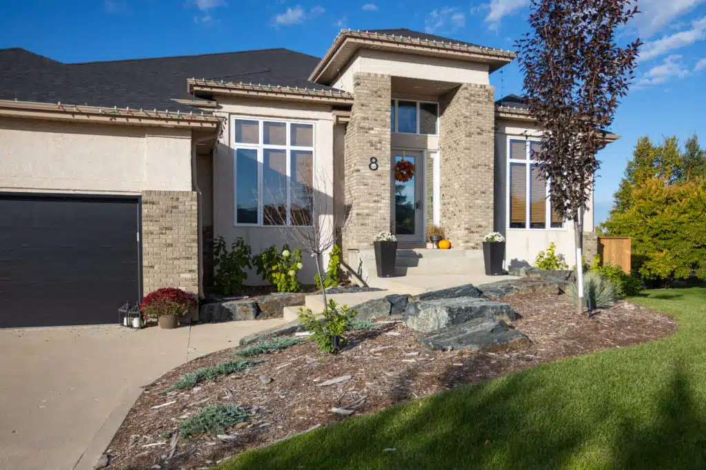 Modern two-storey home with stone accents, black garage, and landscaped front yard