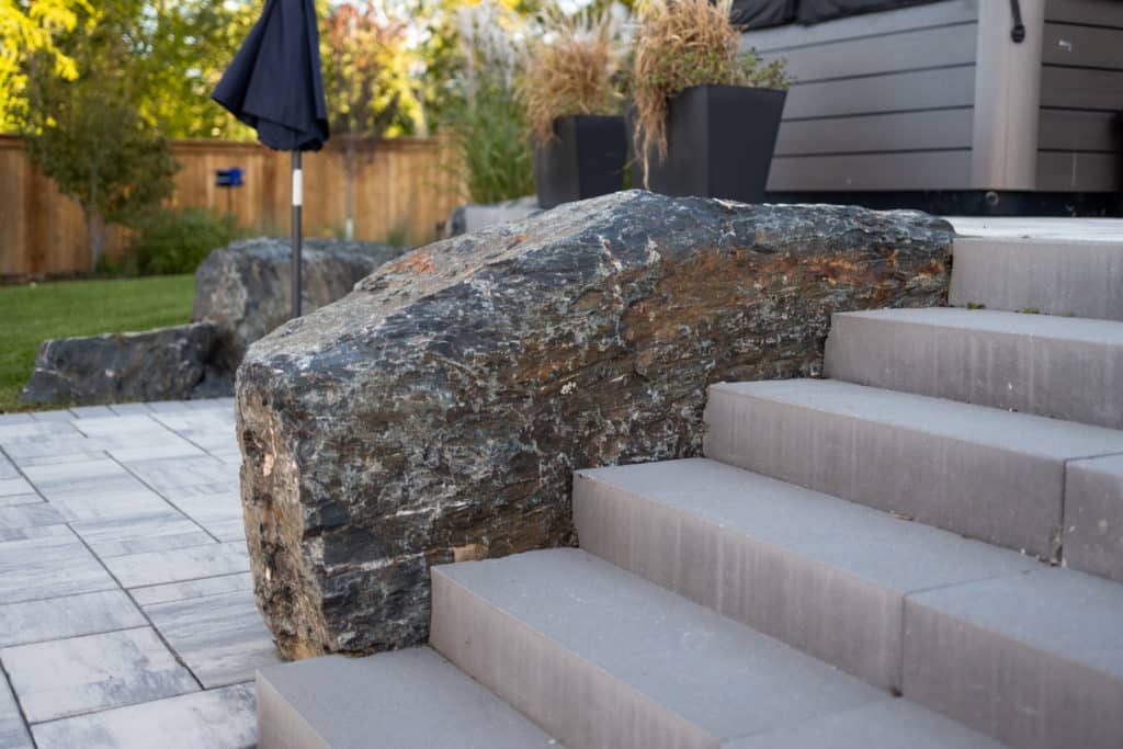 Hardscaping rock feature, concrete stairs and brick patio detail.