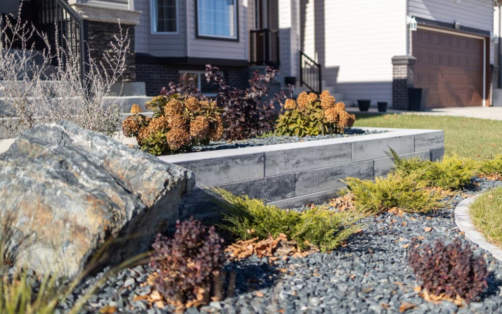 Detail of elevated planters bed, with stone walls and rock features, in Winnipeg front yard.