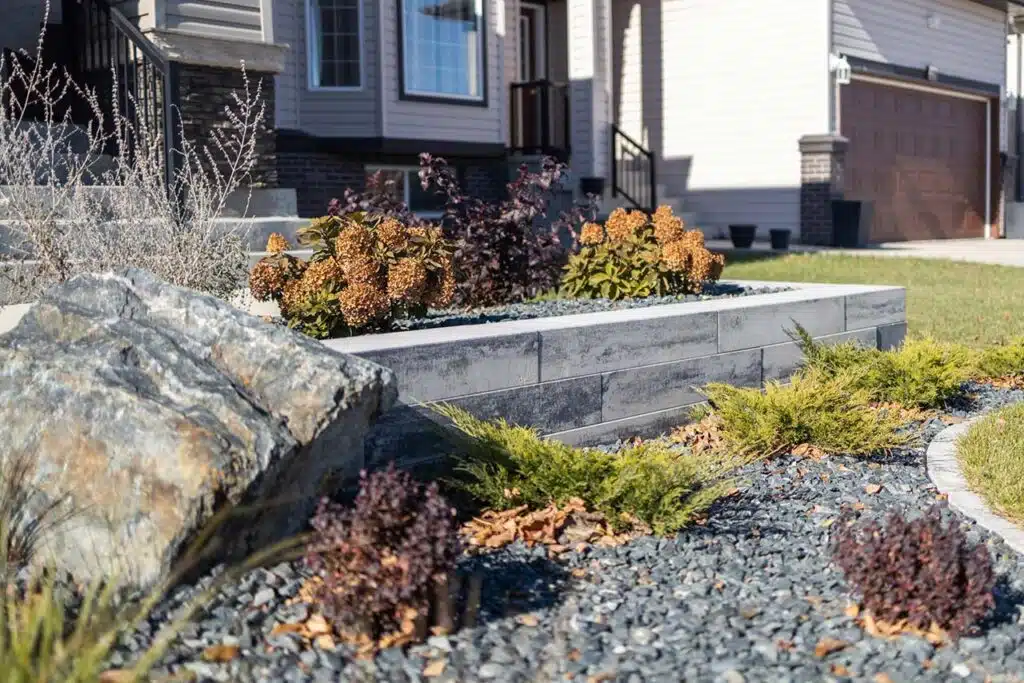 Landscaped front yard with rock garden, retaining wall, and shrubs
