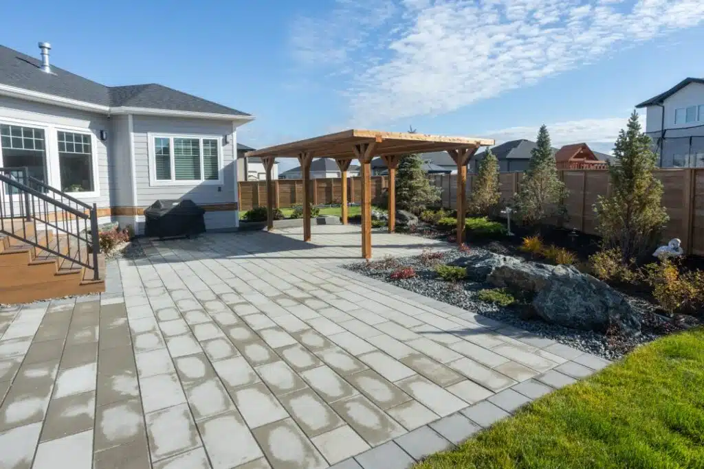 Backyard patio with pergola, landscaping, and paved stone