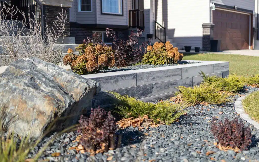 Landscaped front yard with rock garden, retaining wall, and shrubs.