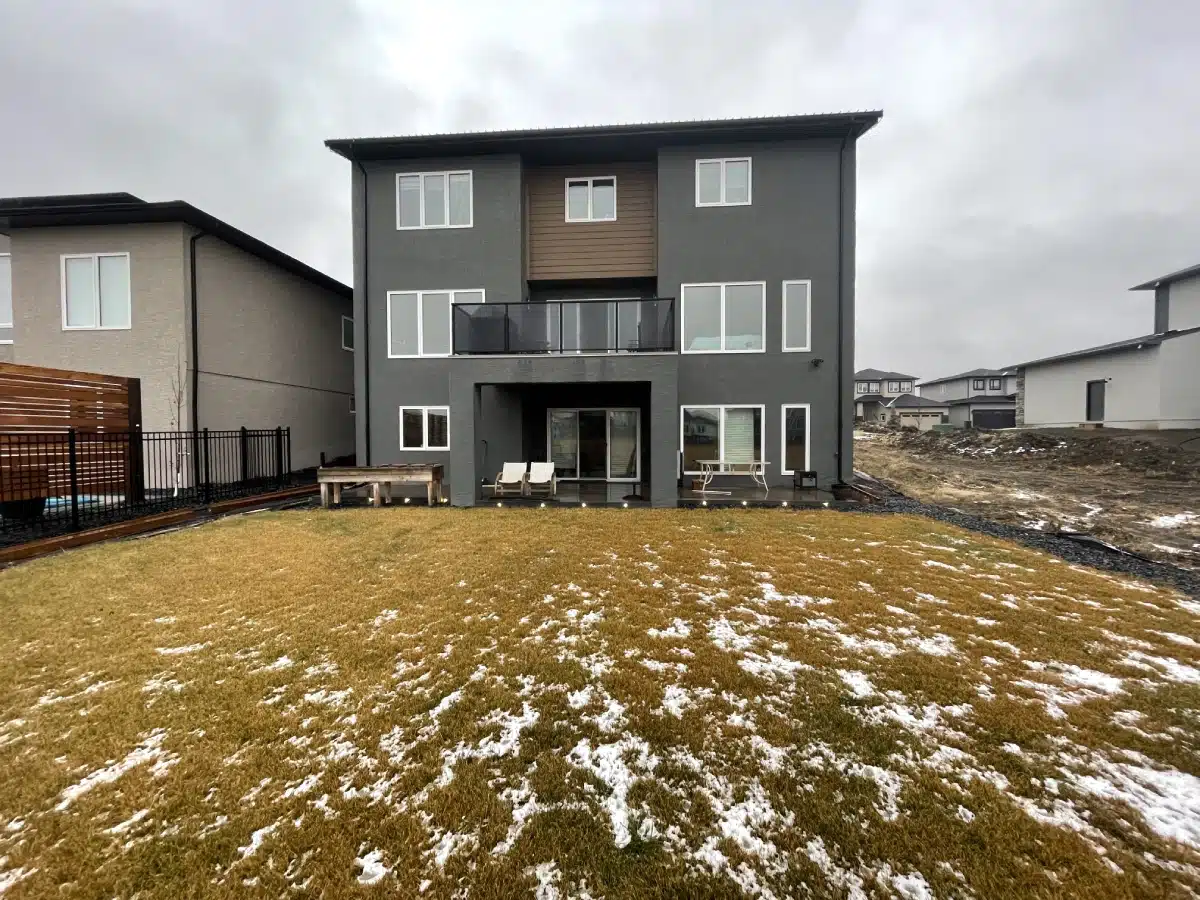 Backyard with a blank patch of grass in the winter.