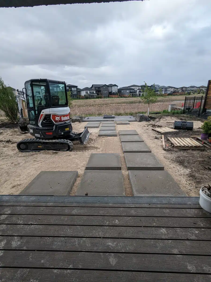 Backyard landscape project in progress; Bobcat leveling ground.