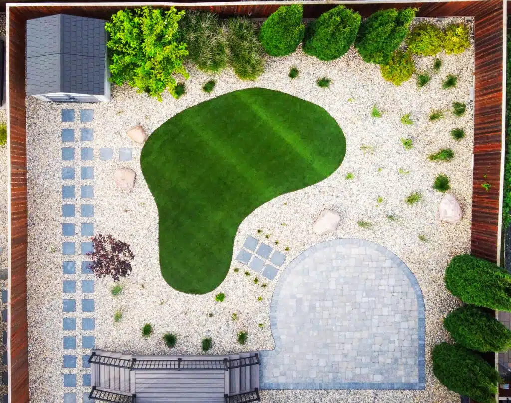 Small backyard space strategically designed with brick patio, rock gardens, pathways and fence.