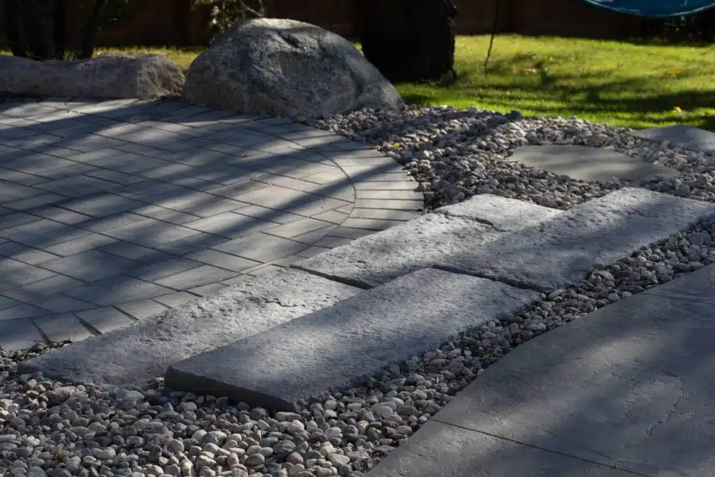 Natural stone steps and paver patio with decorative gravel border.