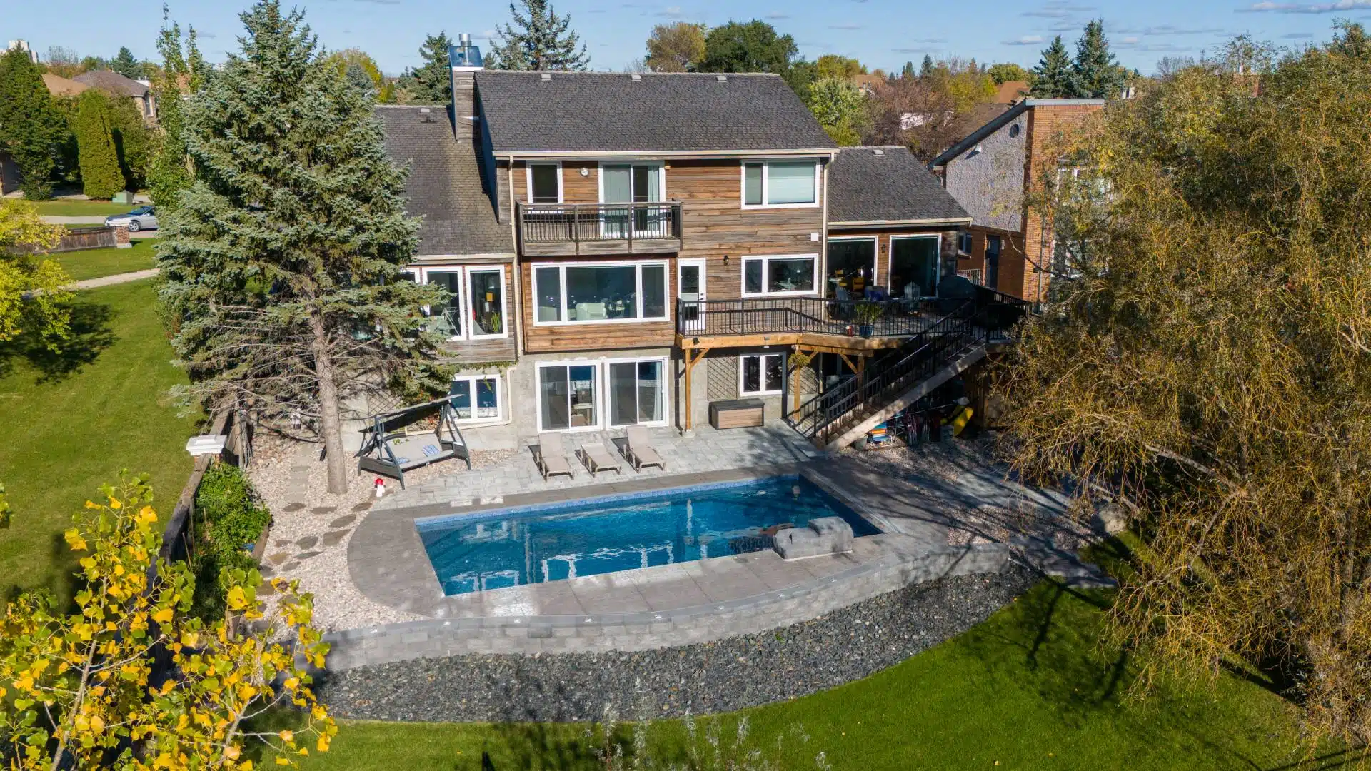 Aerial view of backyard pool, patio, and multi-level deck landscaping.