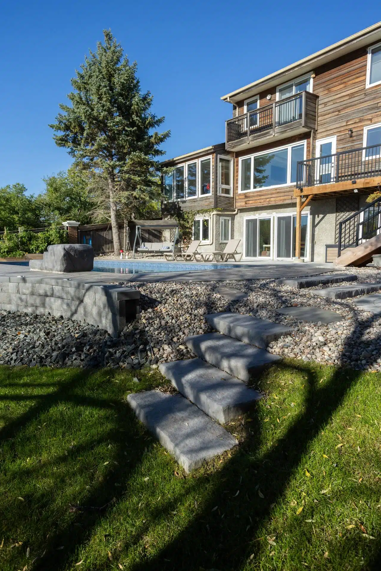 Stone garden steps leading to pool patio and modern deck area.
