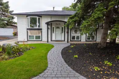 Curved stone walkway leading to front entrance with fresh landscaping