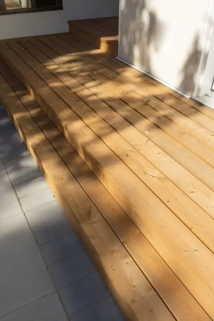 Close-up of cedar deck steps with clean paver surround