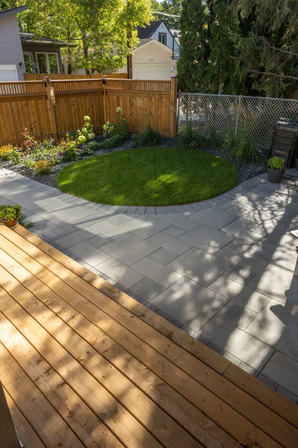 Curved lawn feature with stone border and cedar fence