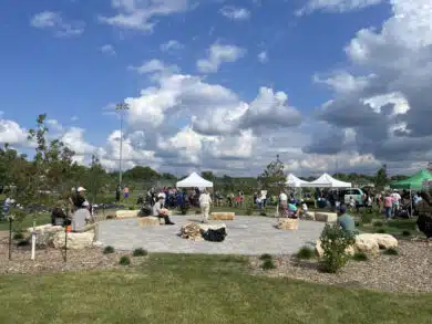 Wide view of community gathering around landscaped circular paver patio