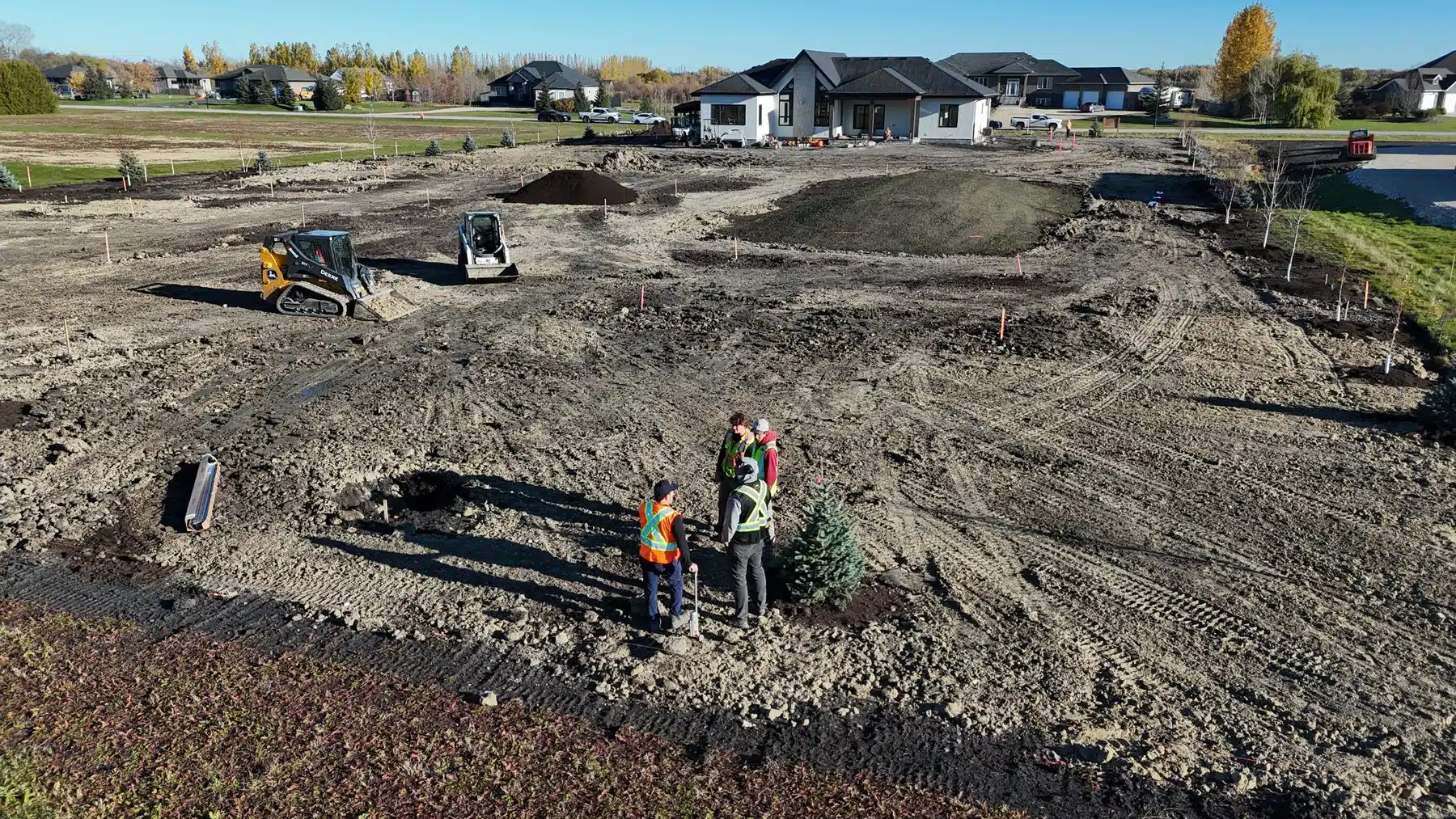 North Coral landscaping crew positioning a tree on a large Winnipeg-area residential property