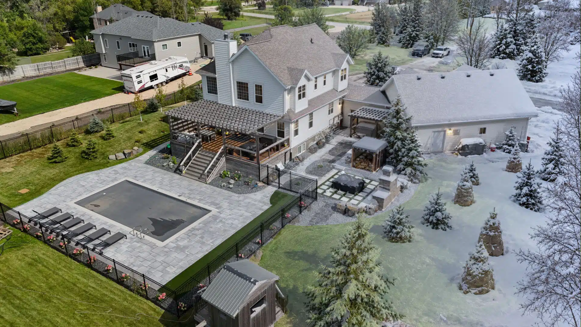Aerial view of a landscaped backyard transitioning from summer to winter, with a pool, patio, pergola, trees, and snow-covered lawn.